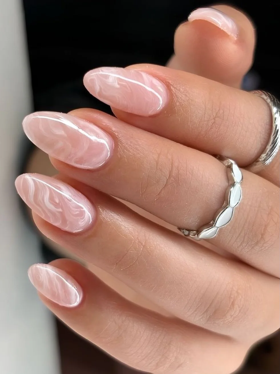 Short pink almond nails with fine-line white marble swirls