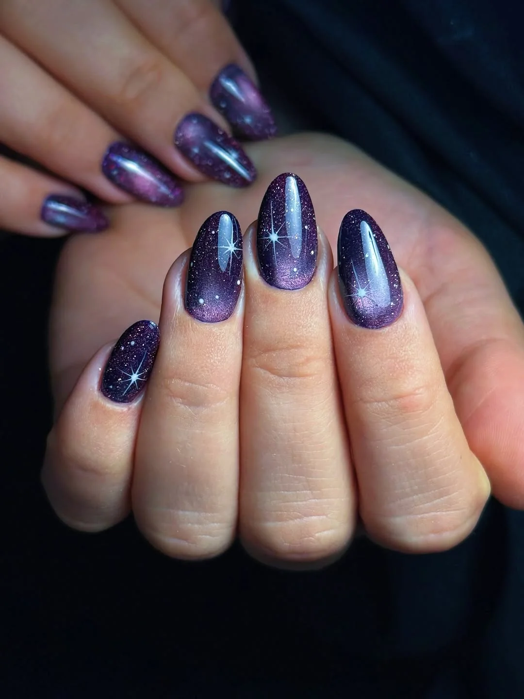 Purple galaxy cat-eye almond nails with sparkly stars