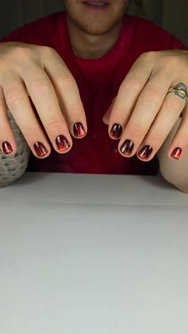 Short men's nails in dark burgundy with black flame detail