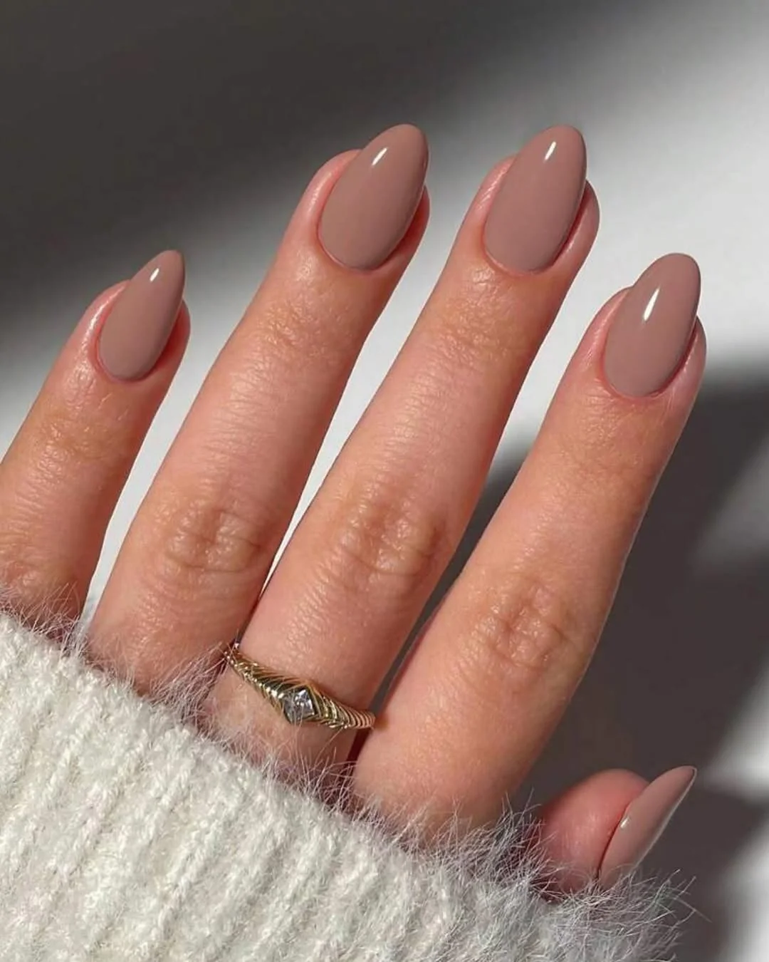 Short taupe nude oval nails with a glossy finish