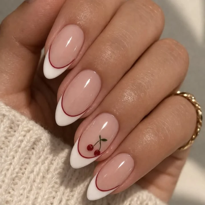 Nude almond nails with white and red double French tips and a cherry accent