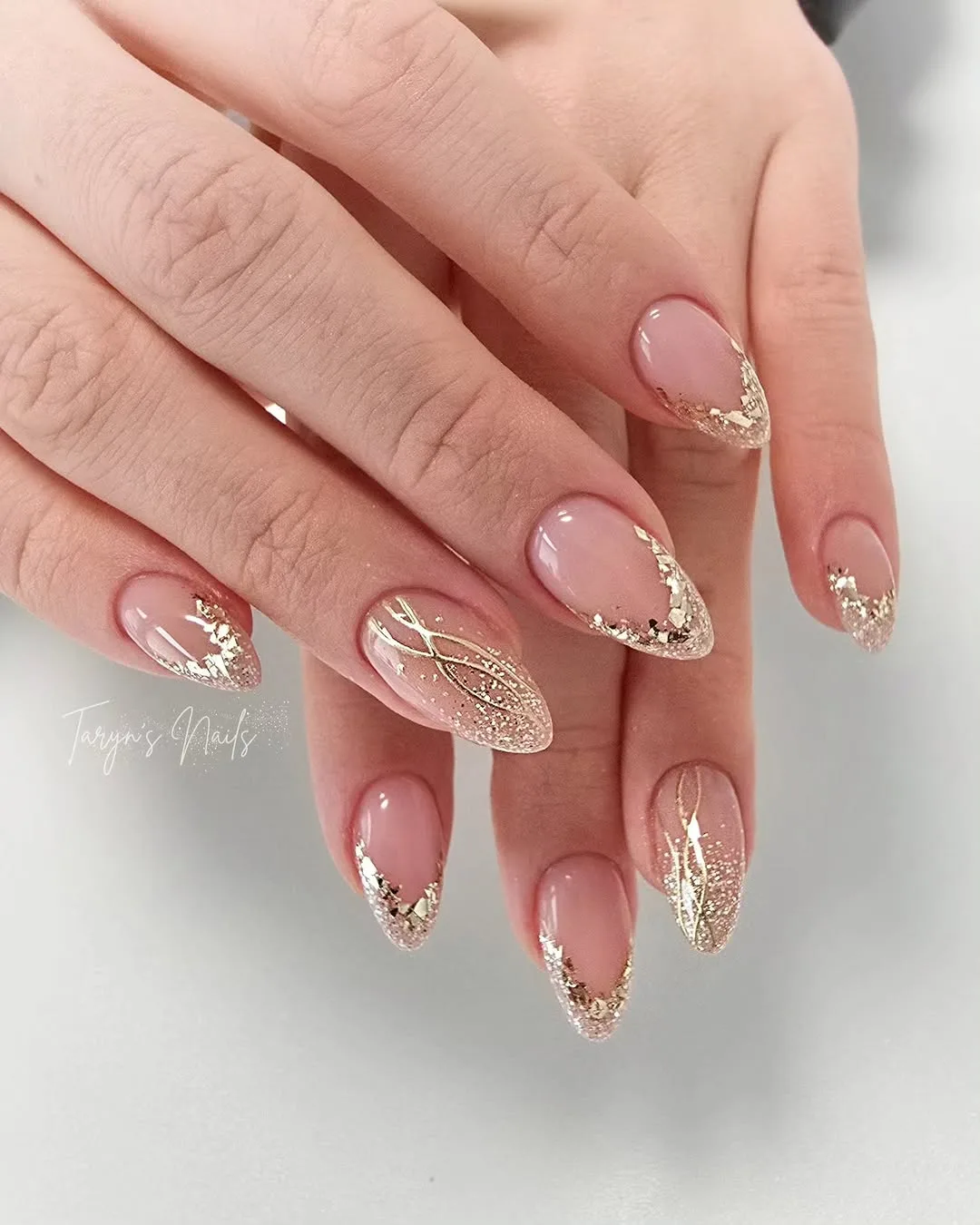 Sheer nude almond nails with thin gold line details