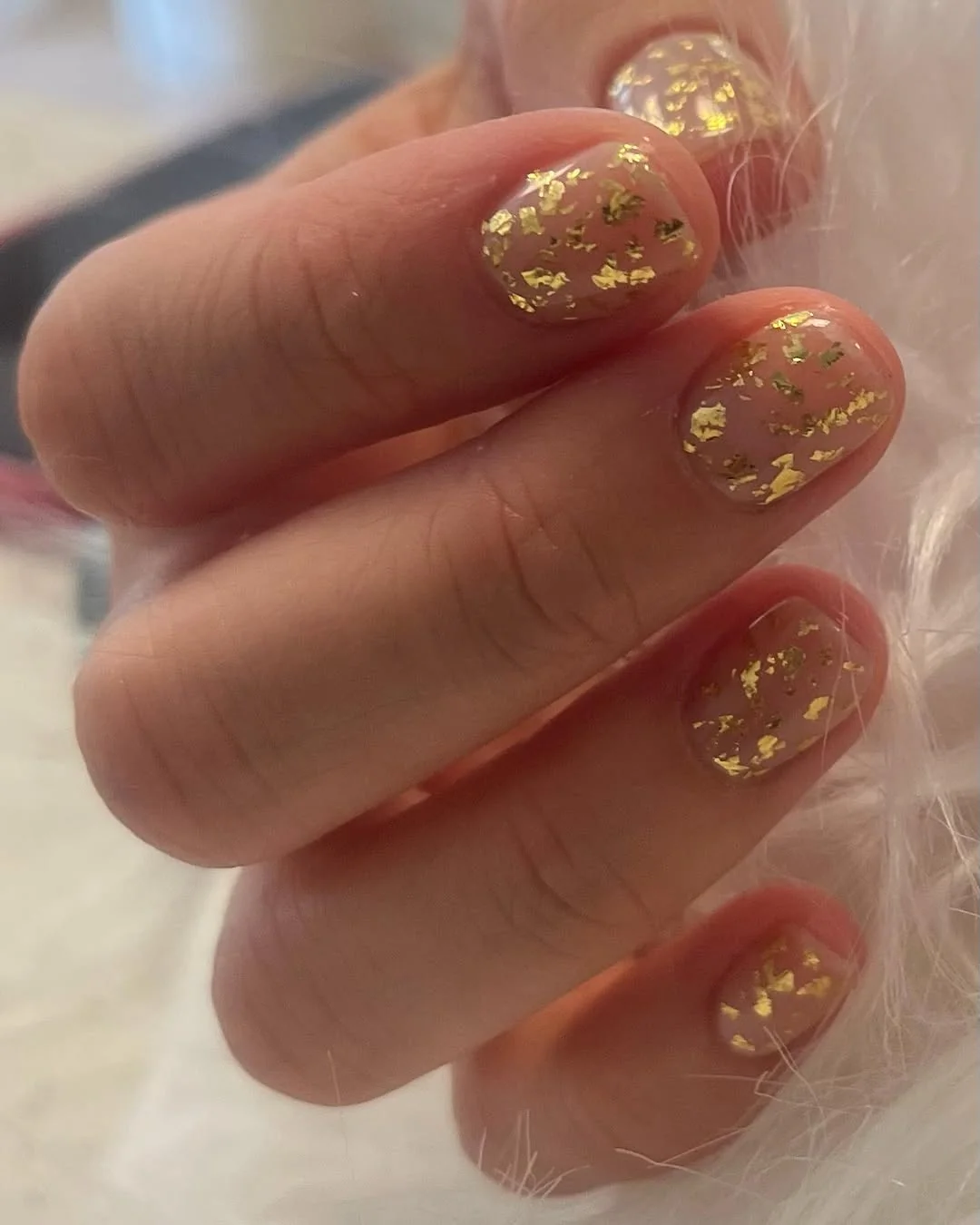 Short nude nails with gold foil accent flakes