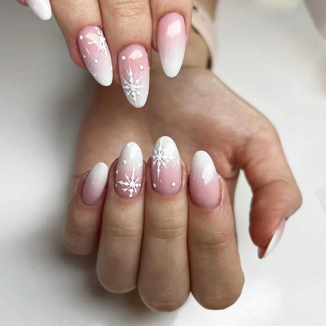Pink to white ombré almond nails with white snowflake art