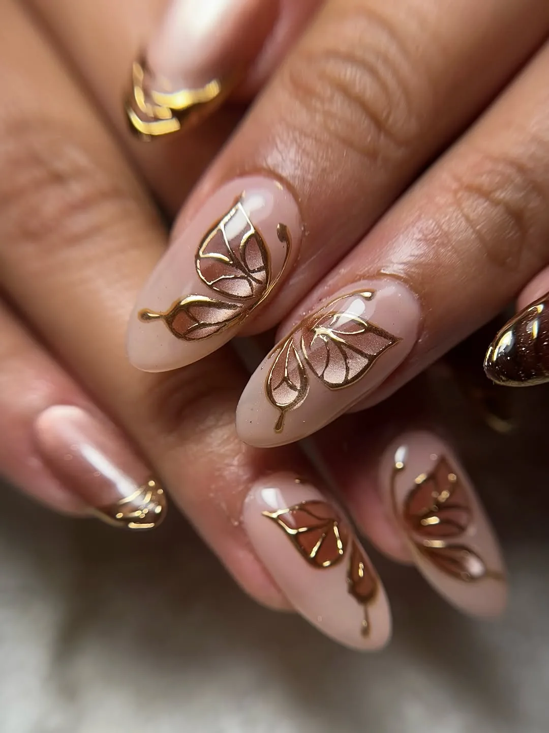 Nude nails with gold swirl flower art