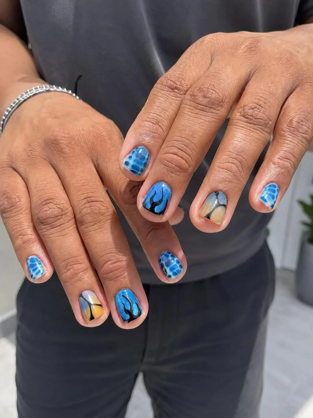 Short men's nails in blue with abstract art and negative-space shapes