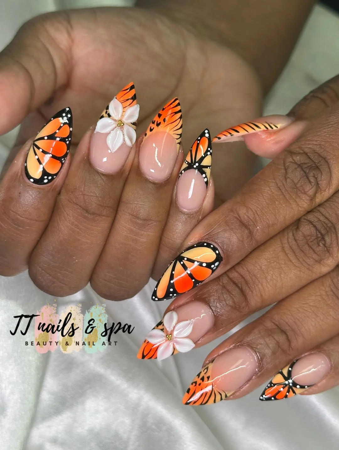Short nails with orange monarch butterfly art and white flowers