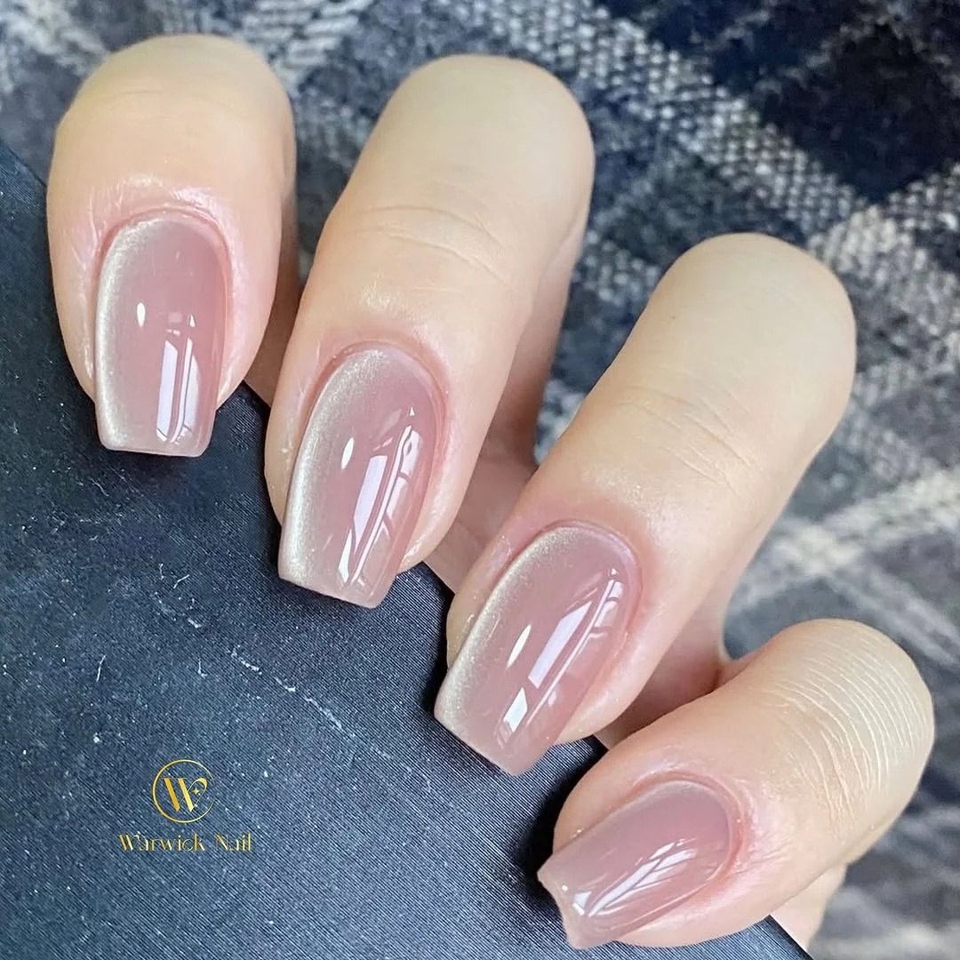 Sheer nude square nails with a diagonal cat-eye stripe