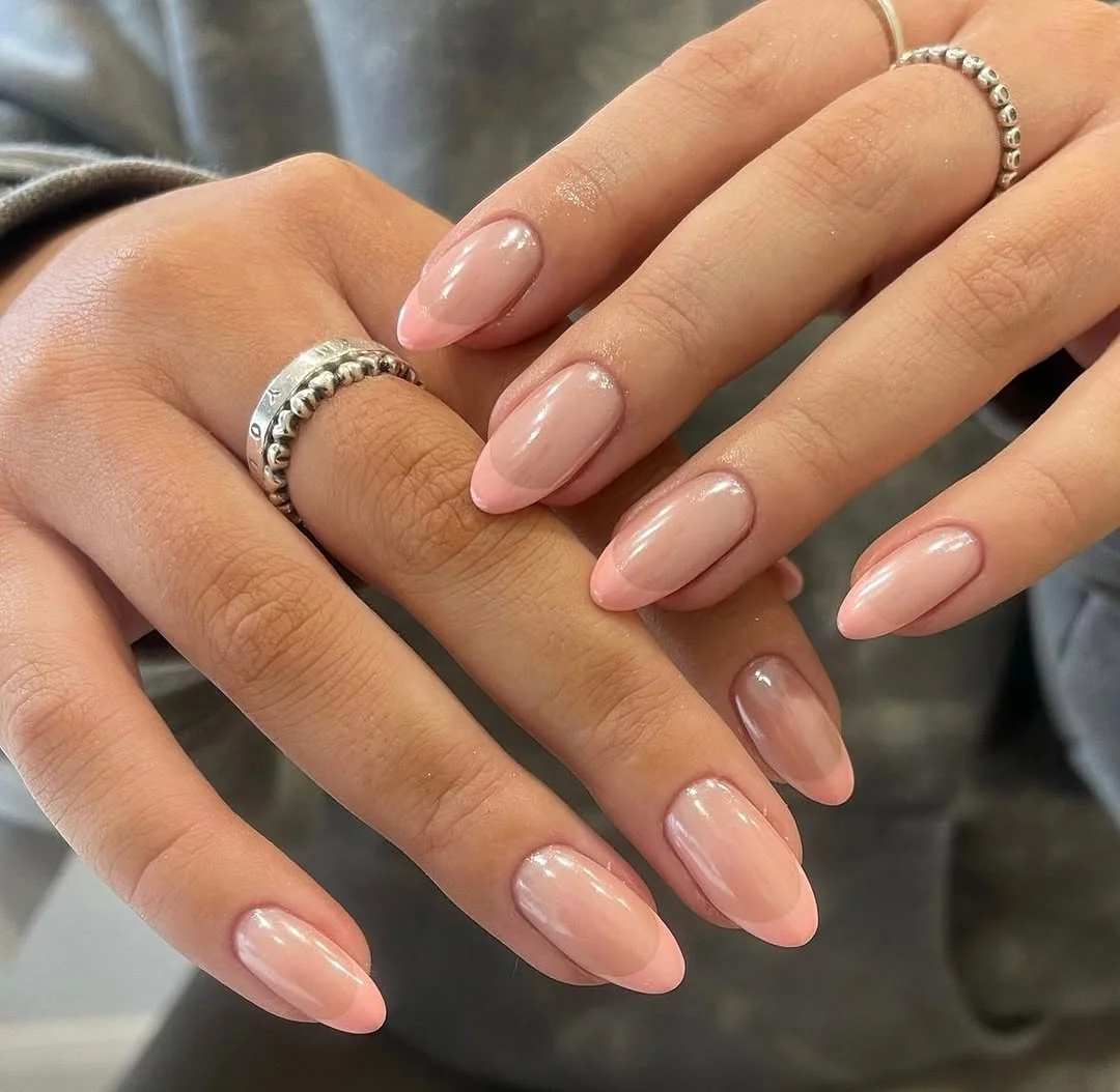 Glazed nude peach almond nails with a glossy finish