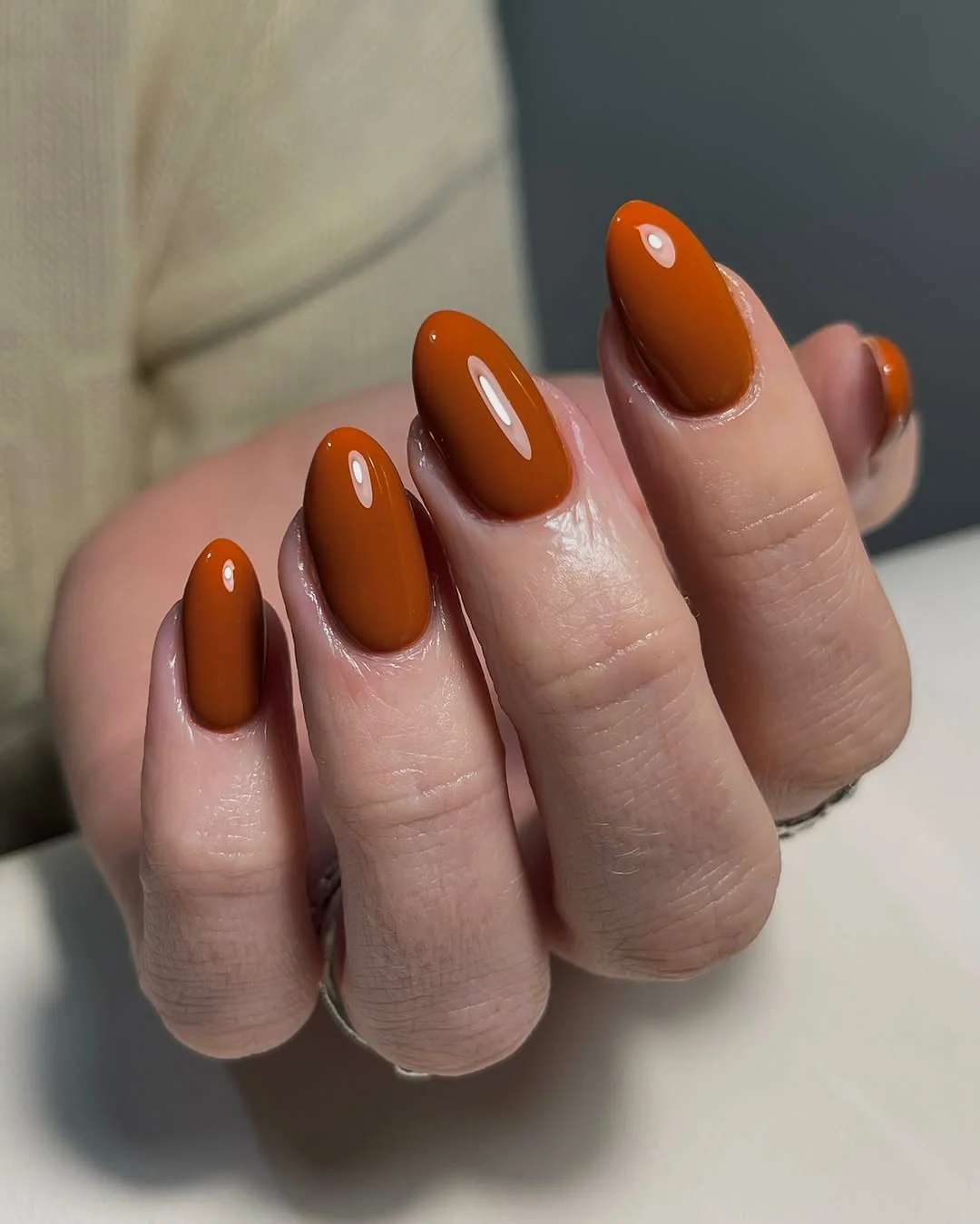 Burnt orange almond nails with a glossy finish