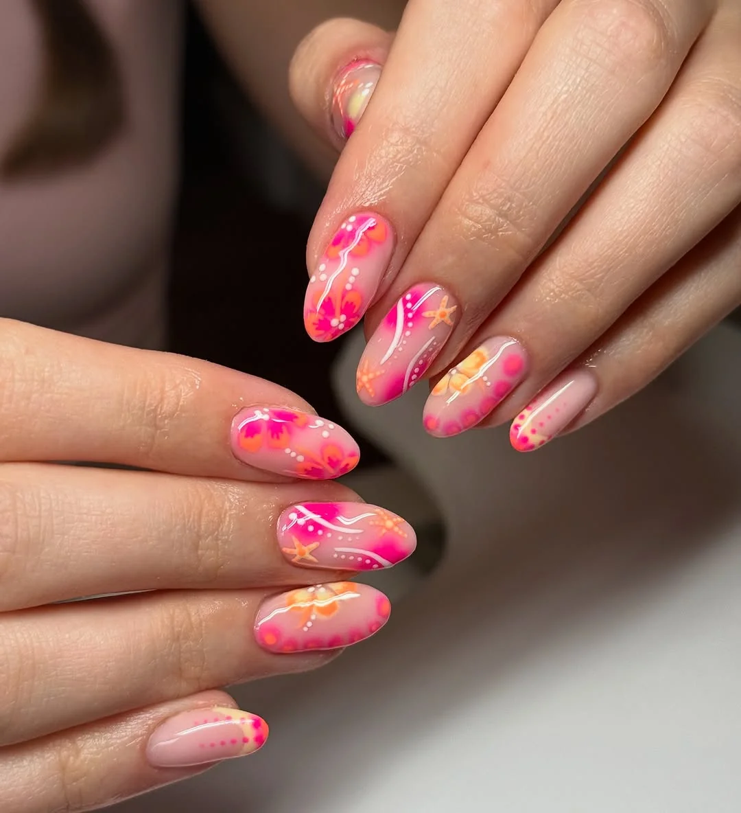 Bright pink and coral almond nails with hand-painted hibiscus flowers