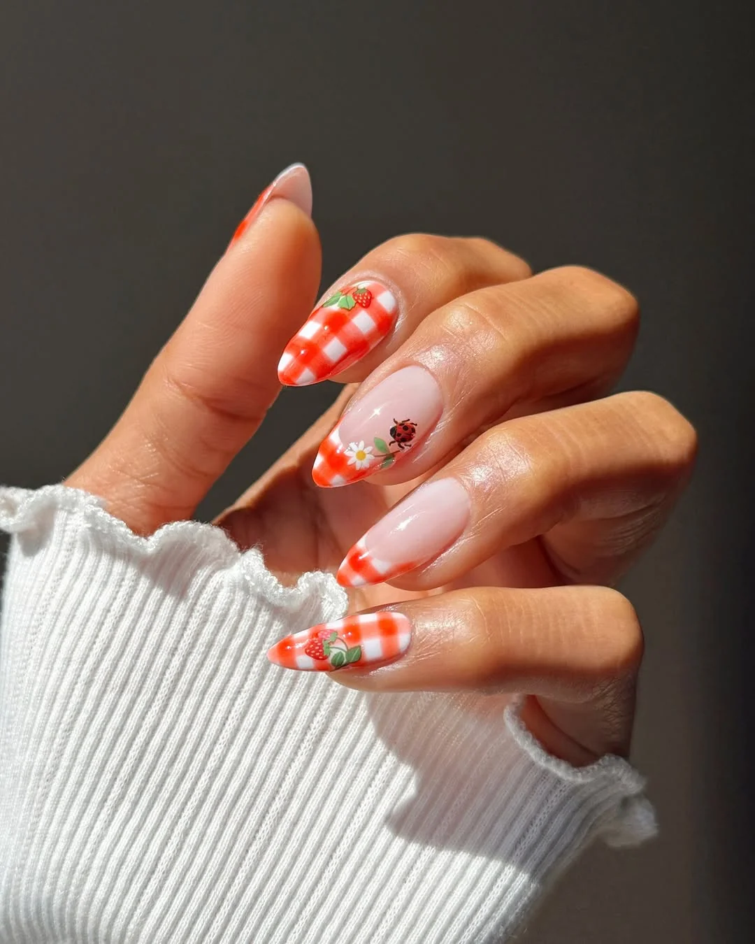 Orange gingham almond nails with ladybug and strawberry accents