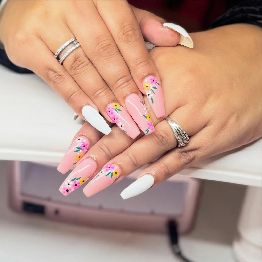 Pink coffin nails with colorful floral accents and white tips