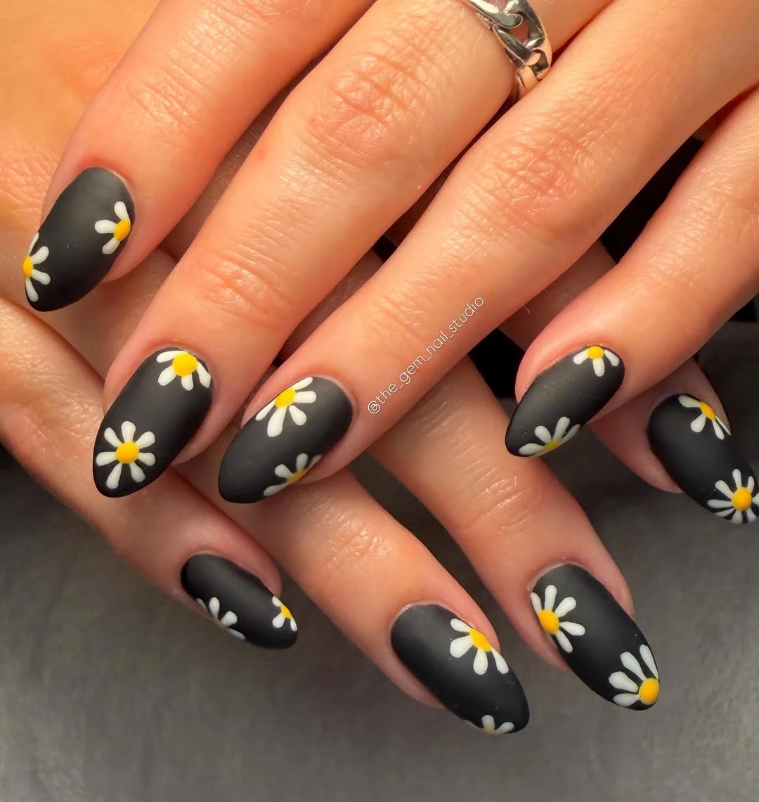 Matte black almond nails with white and yellow daisy art