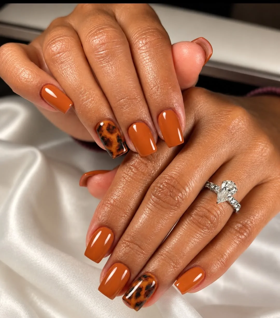 Burnt orange short square nails with tortoiseshell accent nails