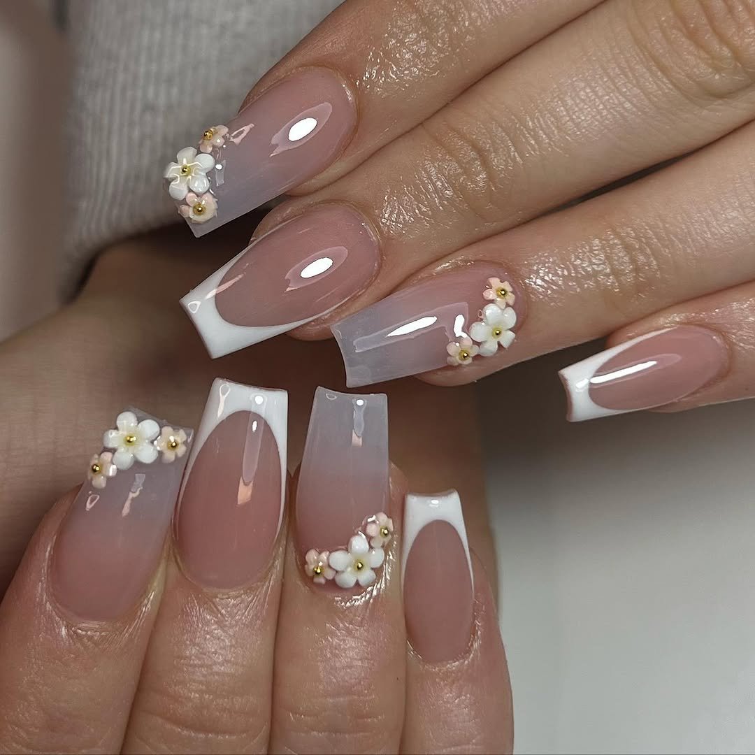 Coffin nails with a nude brown base, white French tips, pearls and tiny flowers