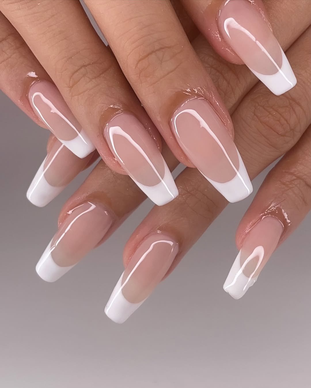 Long coffin nails with a sheer pink base and double white French lines