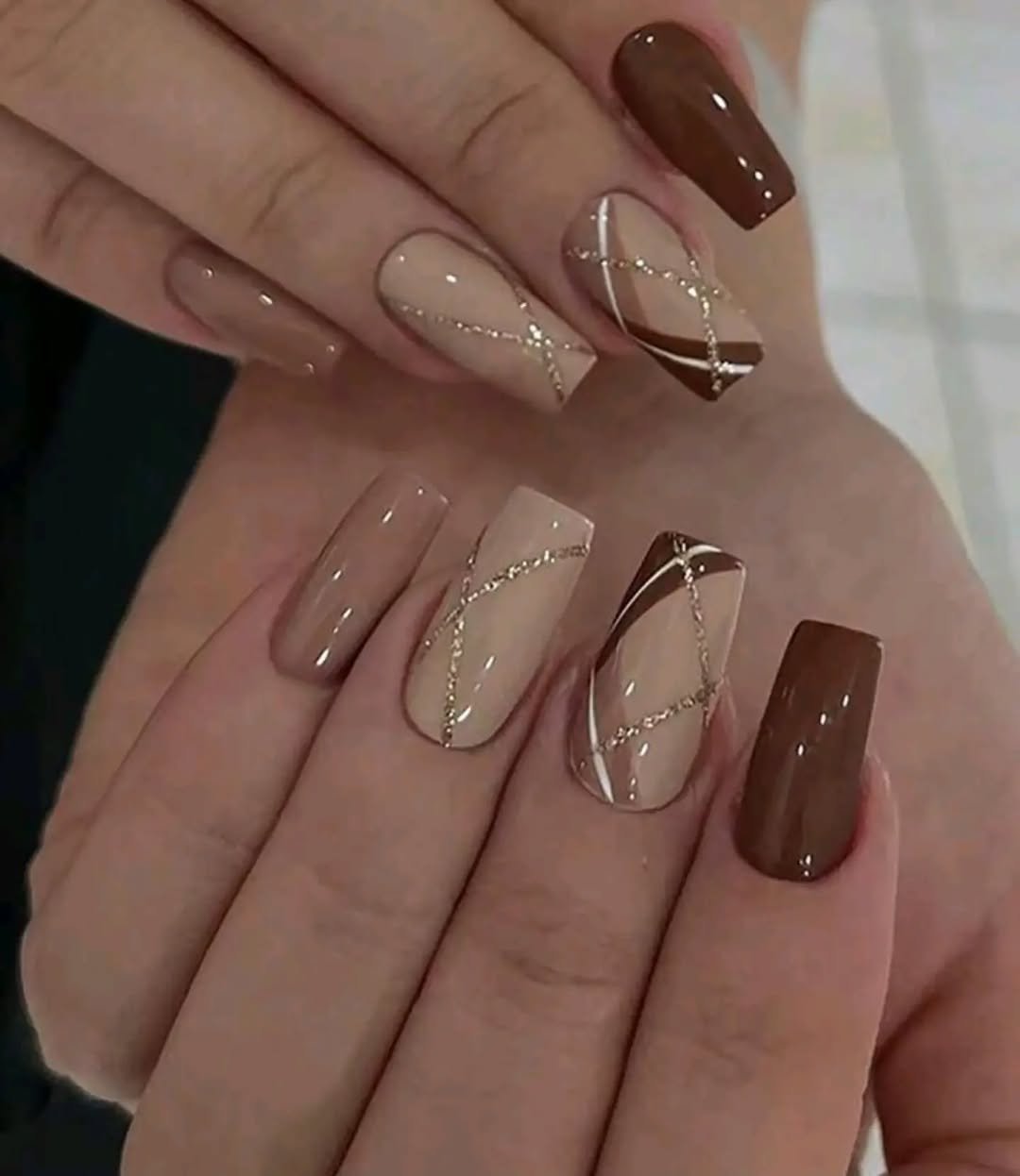 Nude and brown nails with thin gold lines